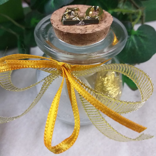 primo piano barattolino vasetto vetro tappo sughero numero 50 di anni matrimonio anniversario nozze oro confezionato confetti bianchi dorati tulle portaconfetti