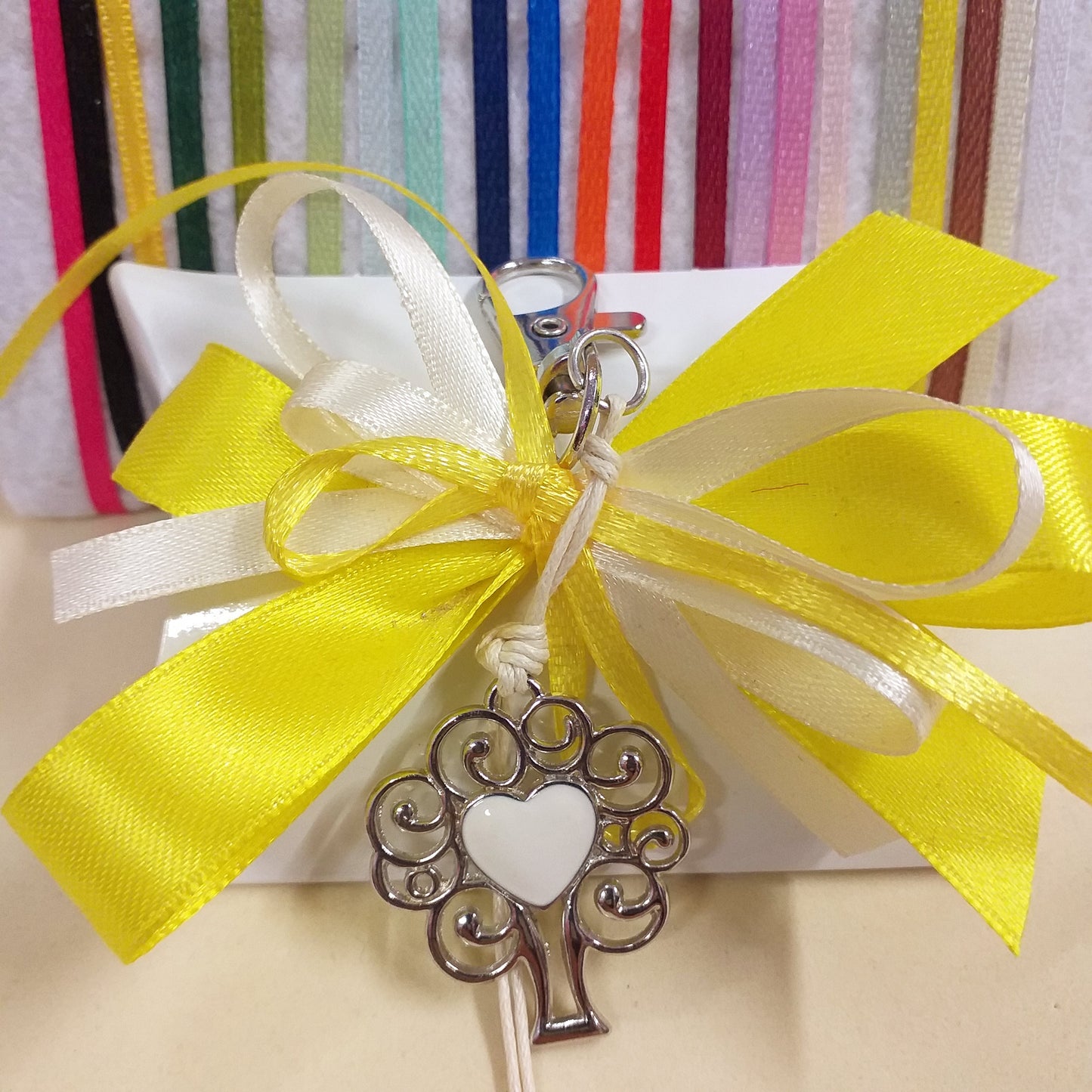 giallo e crema segnaposto bomboniera bustina portaconfetti bianca confezionata confetti portachiavi cuore smaltato con ciondolo metallo albero della vita moschettone cordino cerato colori dei nastri