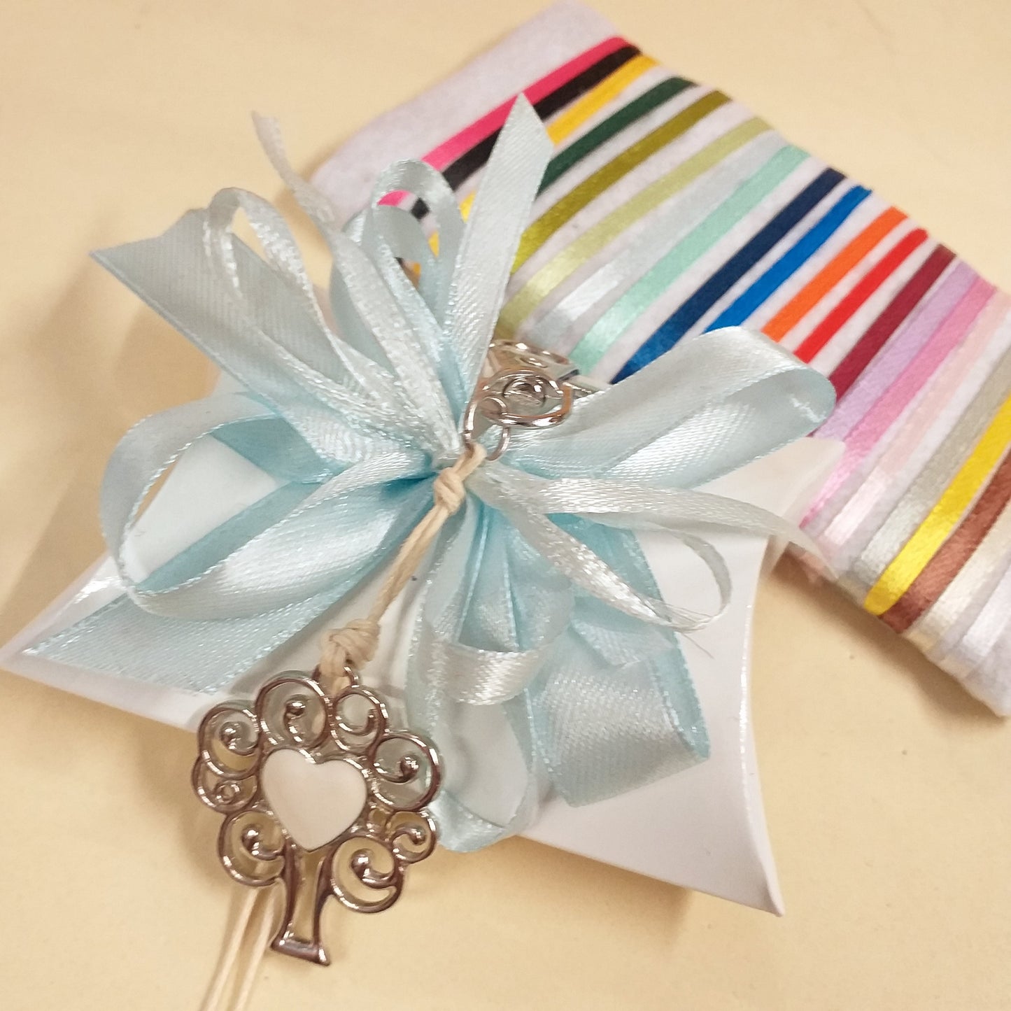azzurro chiaro celeste segnaposto bomboniera bustina portaconfetti bianca confezionata confetti portachiavi cuore smaltato con ciondolo metallo albero della vita moschettone cordino cerato colori dei nastri