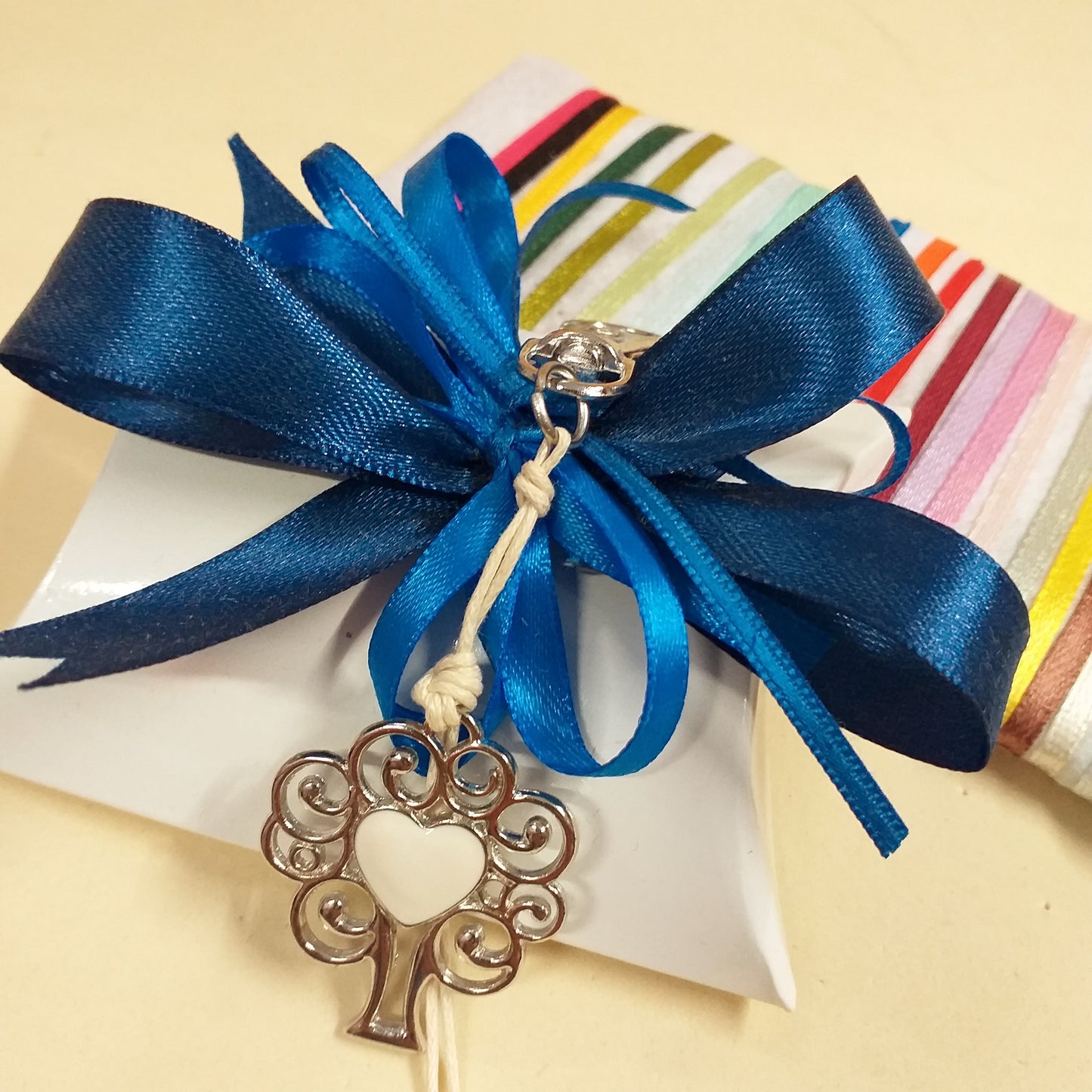 blu e bluette segnaposto bomboniera bustina portaconfetti bianca confezionata confetti portachiavi cuore smaltato con ciondolo metallo albero della vita moschettone cordino cerato colori dei nastri