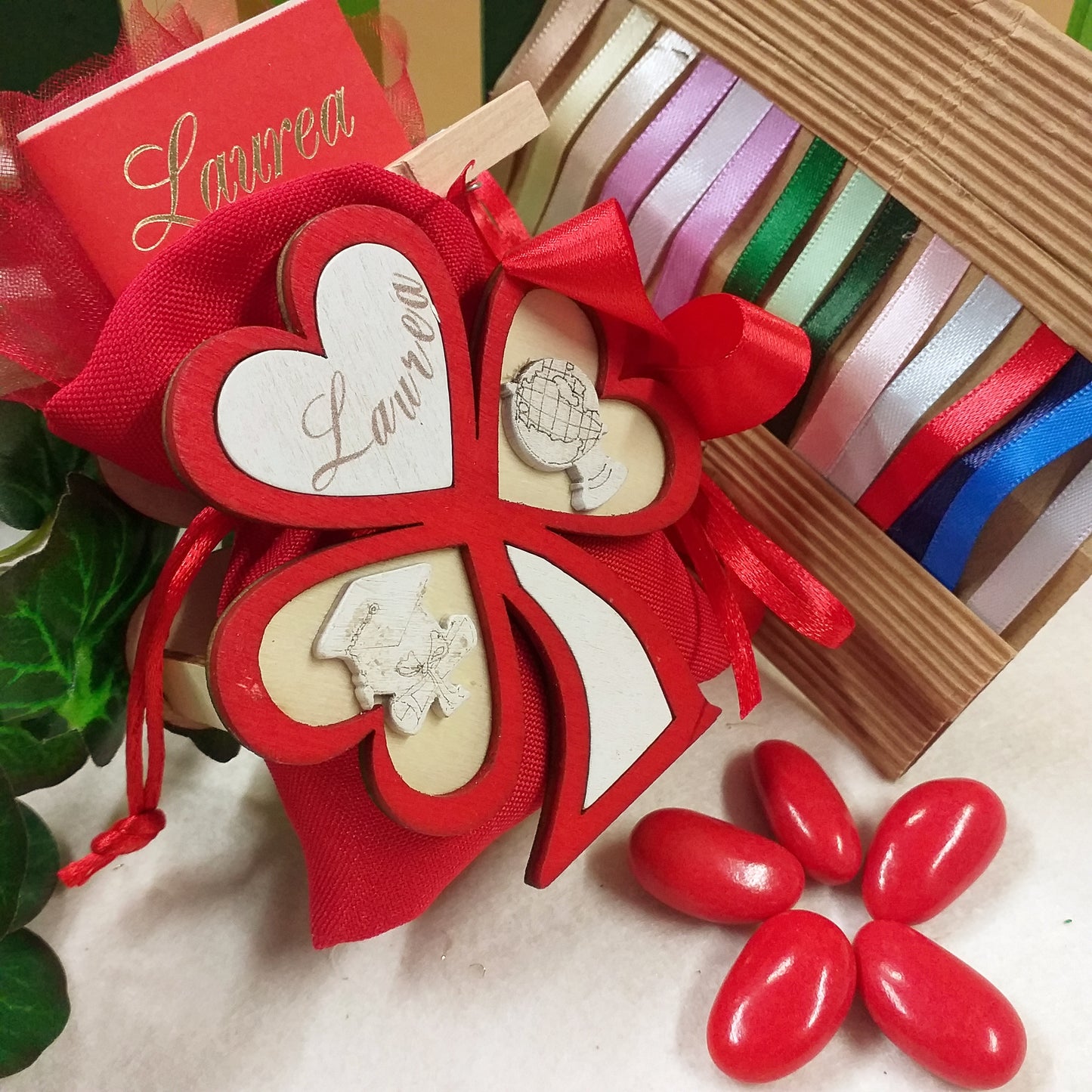 packaging albero della vita tre cuori piantina legno bianco rosso simboli laurea cappello tocco mappamondo scritta da confezionare come bomboniere idee originali le più belle sacchettino juta rosso 5 confetti bigliettino stampato mollettina