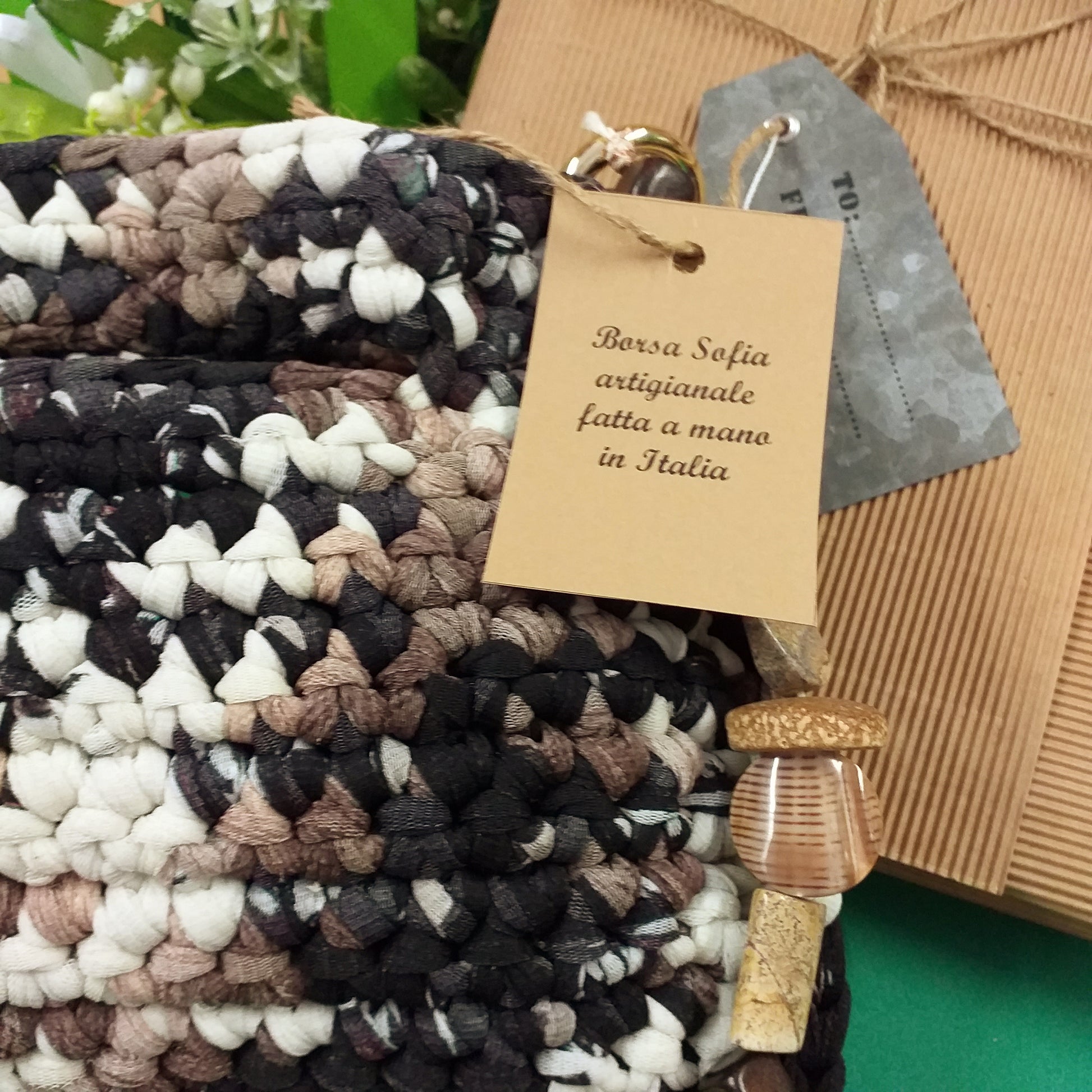 particolare lato superiore con etichetta di Borsa Sofia di fettuccia lycra retina tulle bianco-nero marrone artigianale fatta a mano in Italia modello pochette cerimonia matrimonio giorno sera manico gioiello catena perle pietre busta regalo