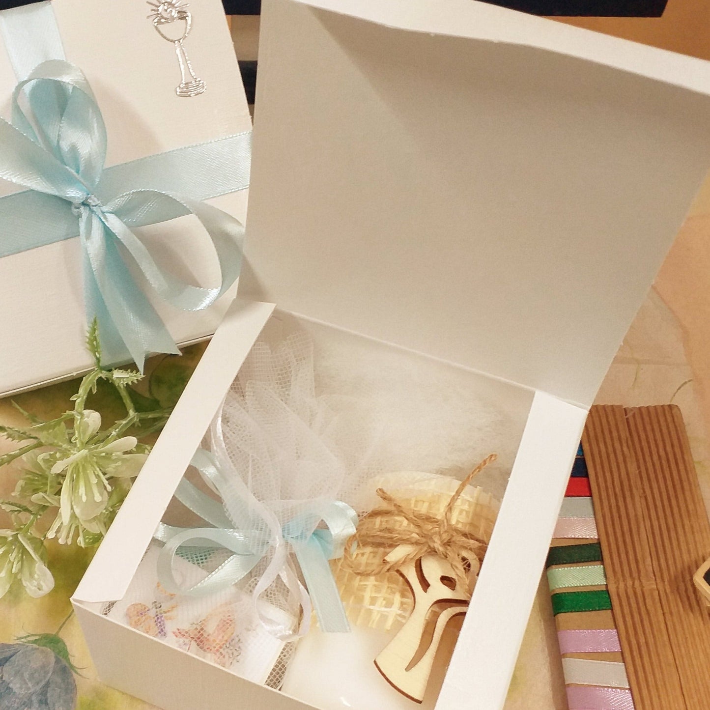 dall'alto scatole bianche basse quadrate coperchio bordo all'interno uso packaging confezionamento oggetti bomboniere fai da te candela croce tau sacchettino confetti