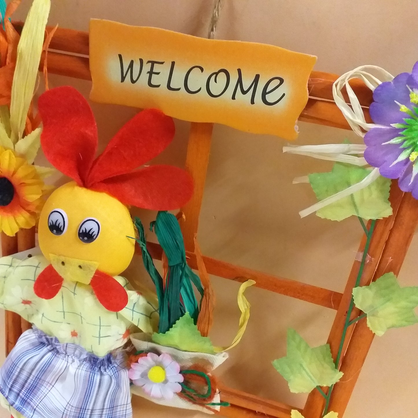 scritta e primo piano di chioccia gallina pezza pannolenci fuoriporta legno finestra welcome fiorellini primula viola foglie edera rafia girasole borsetta margherita pupazzo per decorazioni pasquali vetrine negozi