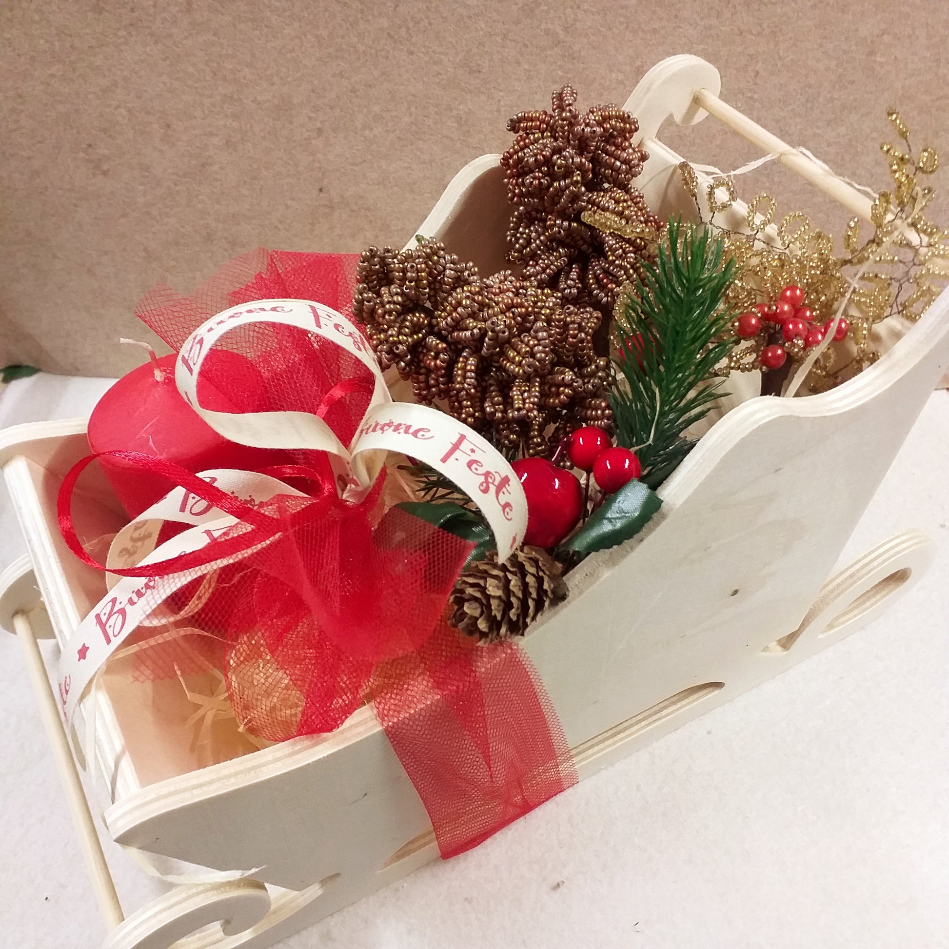 slitta legno pick bacche rosse candela nastro buone feste pigne rametti dorati di natale composizione floreale fioristi perline veneziane idee regalo centrotavola