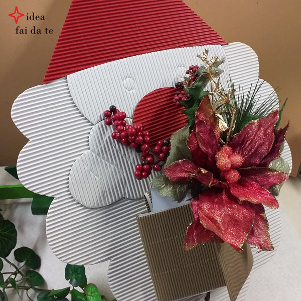 Babbo Natale cappello barba bianca come creare decorazioni di cartoncino con kit fustellati cartone onda bianco rosso e composizione fioristi stella di Natale bacche per packaging confezionamento pacchetti regalo