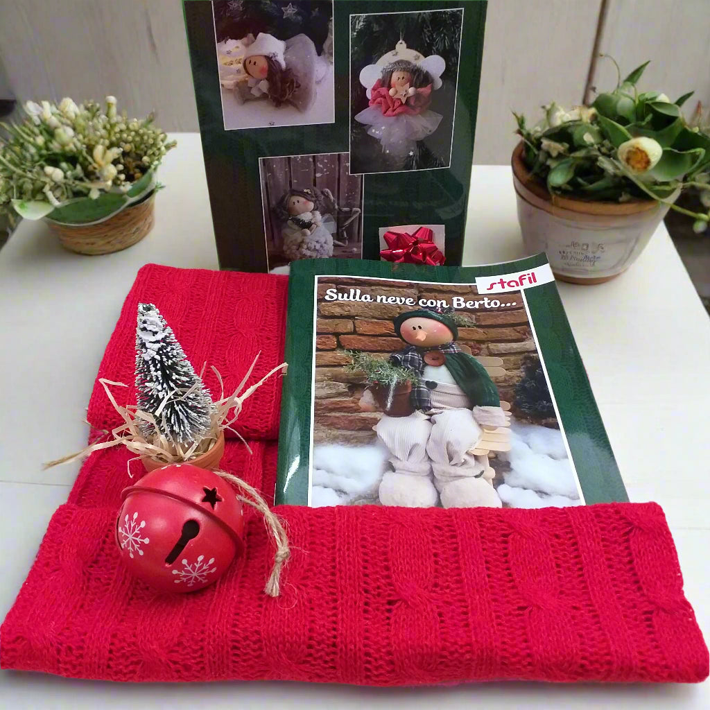 materiali accessori stoffa maglina rossa a trecce, sonaglio di metallo, mini albero pinetto, coccarda regalo di carta rossa, manuale Sulla neve con Berto Stafil Natale 2025 kit cartamodelli libretto di bambole pupazzi in pezza tessuto di feltro pannolenci creare lavoretti creativi bambini fiocchi nascita coccarde ghirlande fuoriporta addobbi decorazioni bamboline angioletti pupazzo di neve