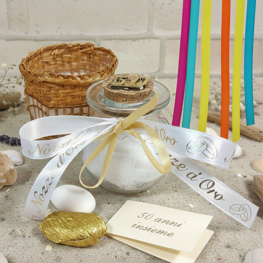 primo piano barattolino vasetto vetro tappo sughero numero 50 di anni matrimonio anniversario nozze oro confezionato confetti bianchi dorati tulle portaconfetti bigliettino altri nastrini colorati cestino packaging