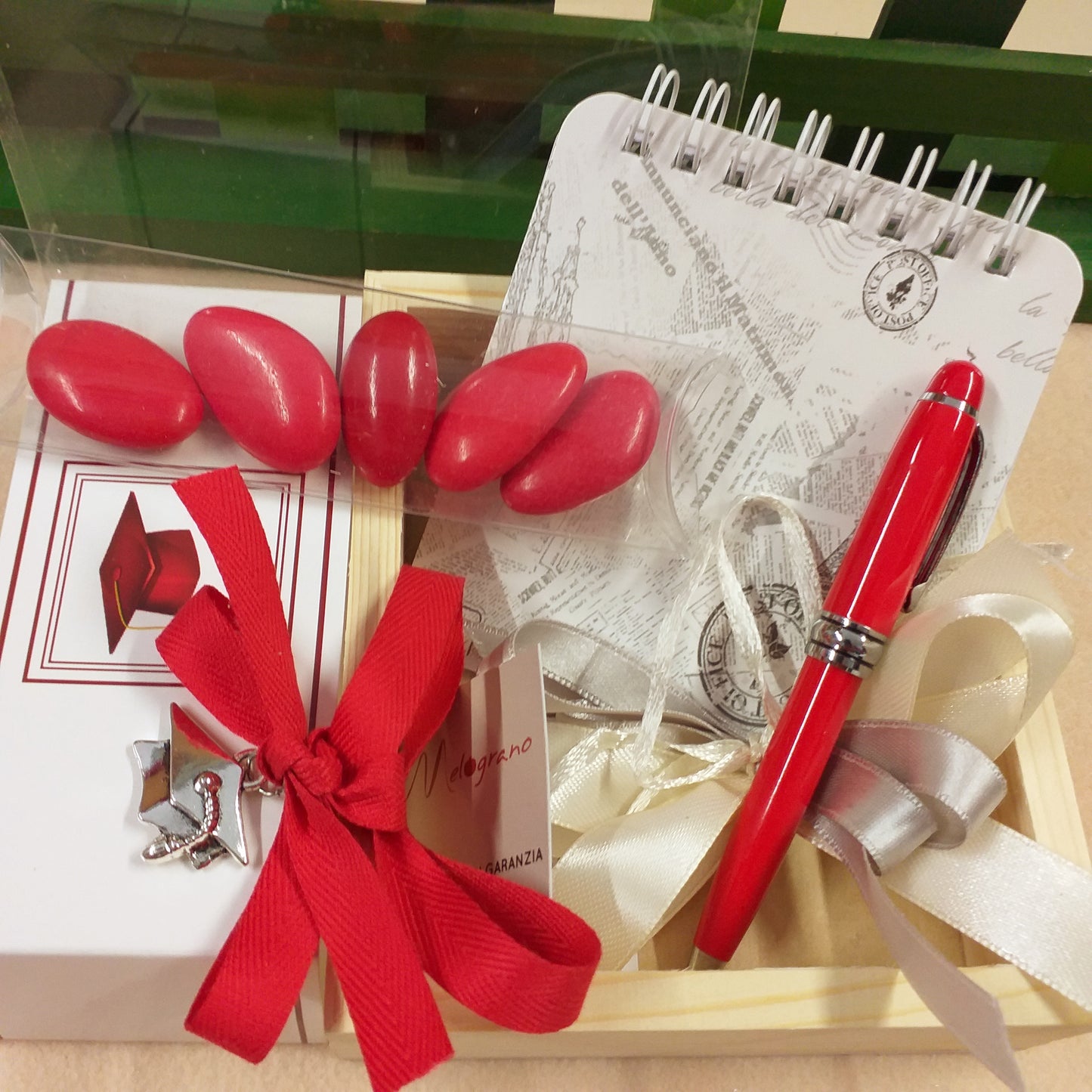 panna e argento coccarda per set di scrittura astuccio legno e plastica scritta laurea penna rossa biro mini block notes ciondolo cappello tocco tubo portaconfetti confetti rossi coccarda nastro confezionata artigianale