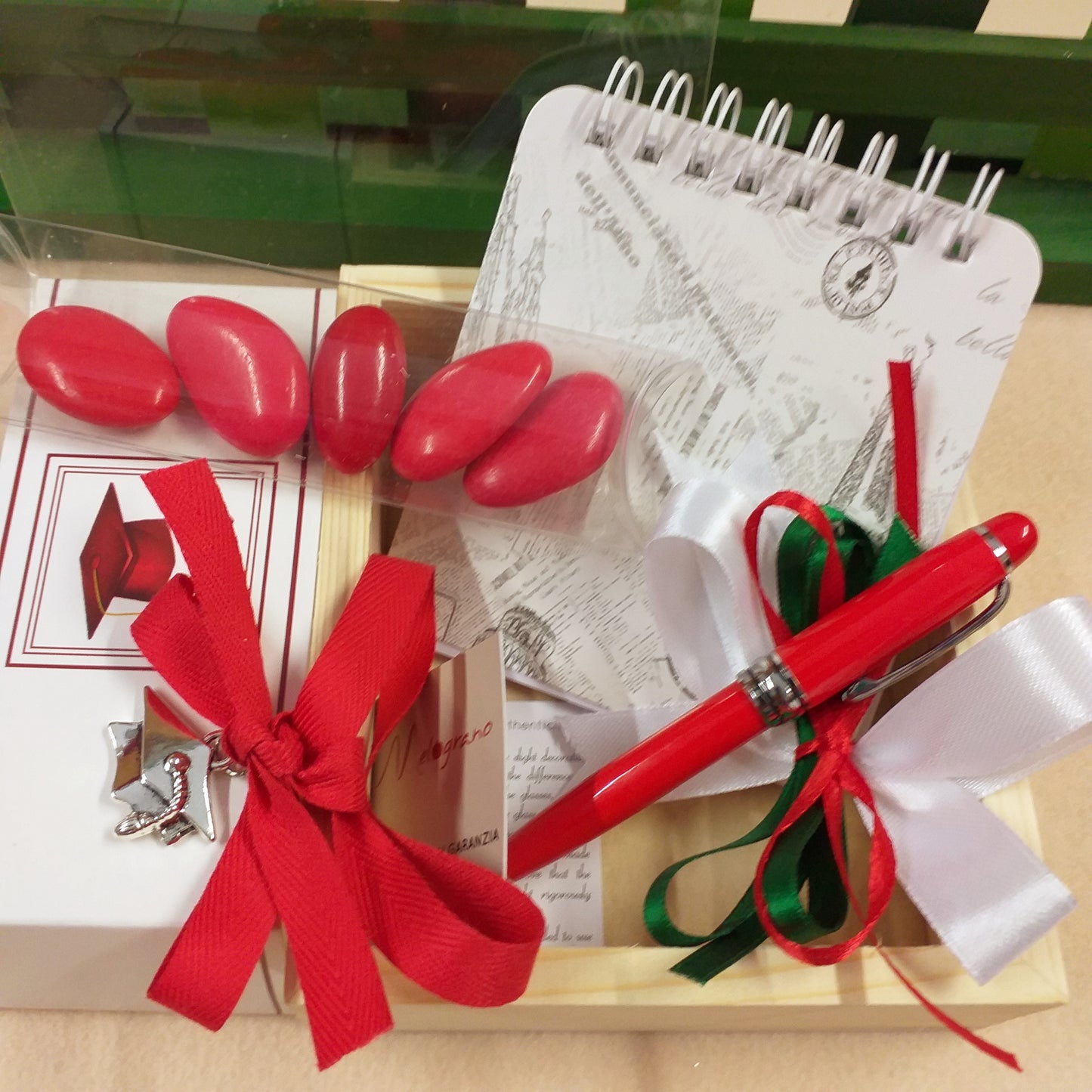 coccarda bianco rosso verde packaging set di scrittura astuccio legno e plastica scritta laurea penna rossa biro mini block notes ciondolo cappello tocco tubo portaconfetti confetti rossi coccarda nastro confezionata artigianale