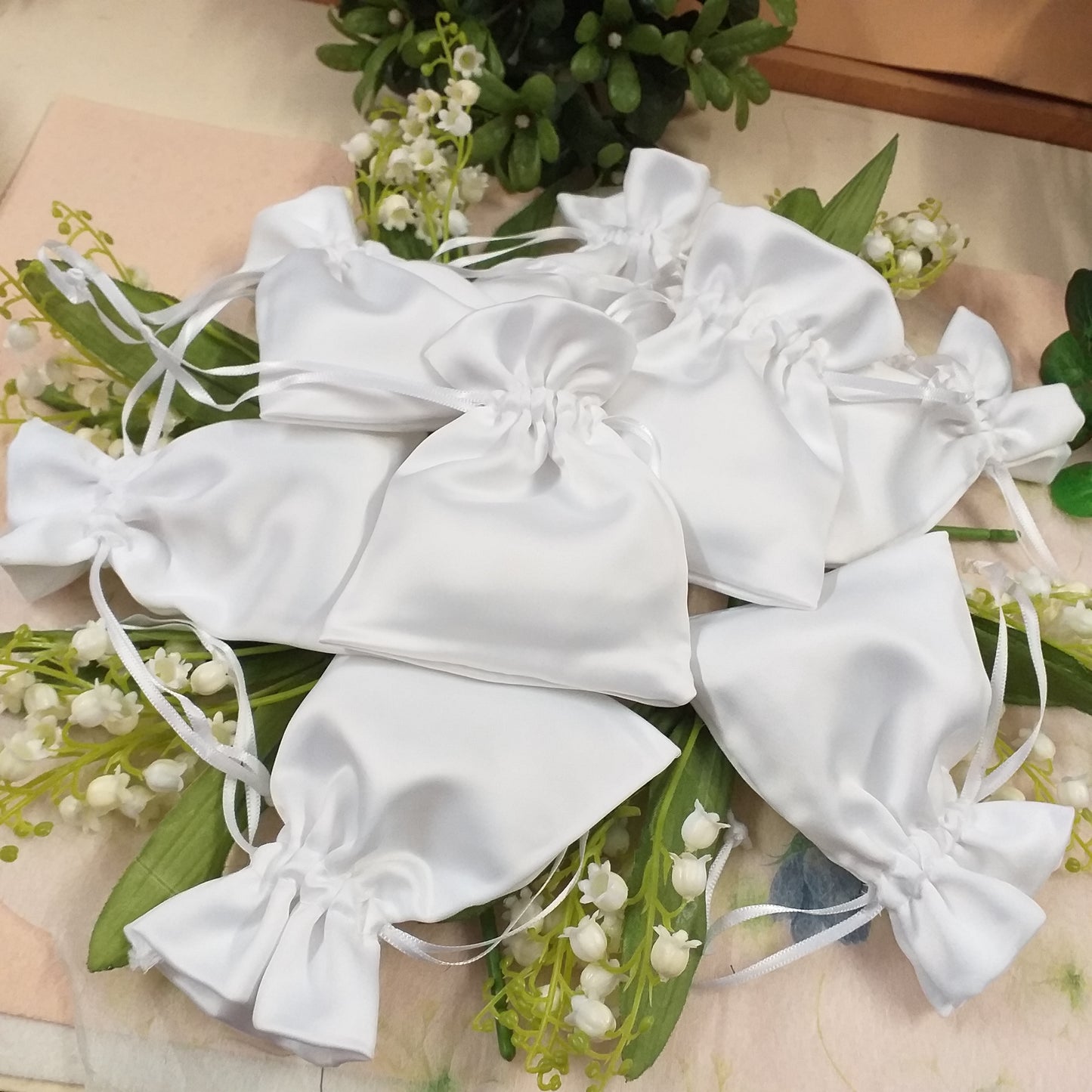 vetrina mughetti e sacchettini bianchi di raso cangiante con tirante portaconfetti per confezionamento bomboniere comunione fai da te confettata cresima matrimonio battesimo
