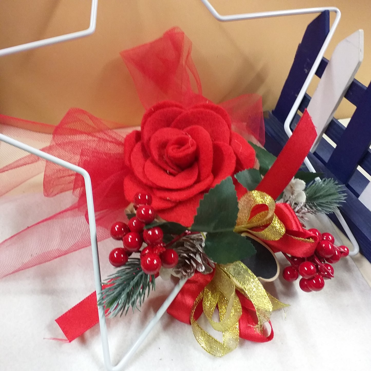 esempio stella metallo ferro struttura base ghirlanda Natale idea fai da te creare composizione floreale fuoriporta o centrotavola con fiori feltro pannolenci pick bacche rosse pino pigne finti artificiali nastro