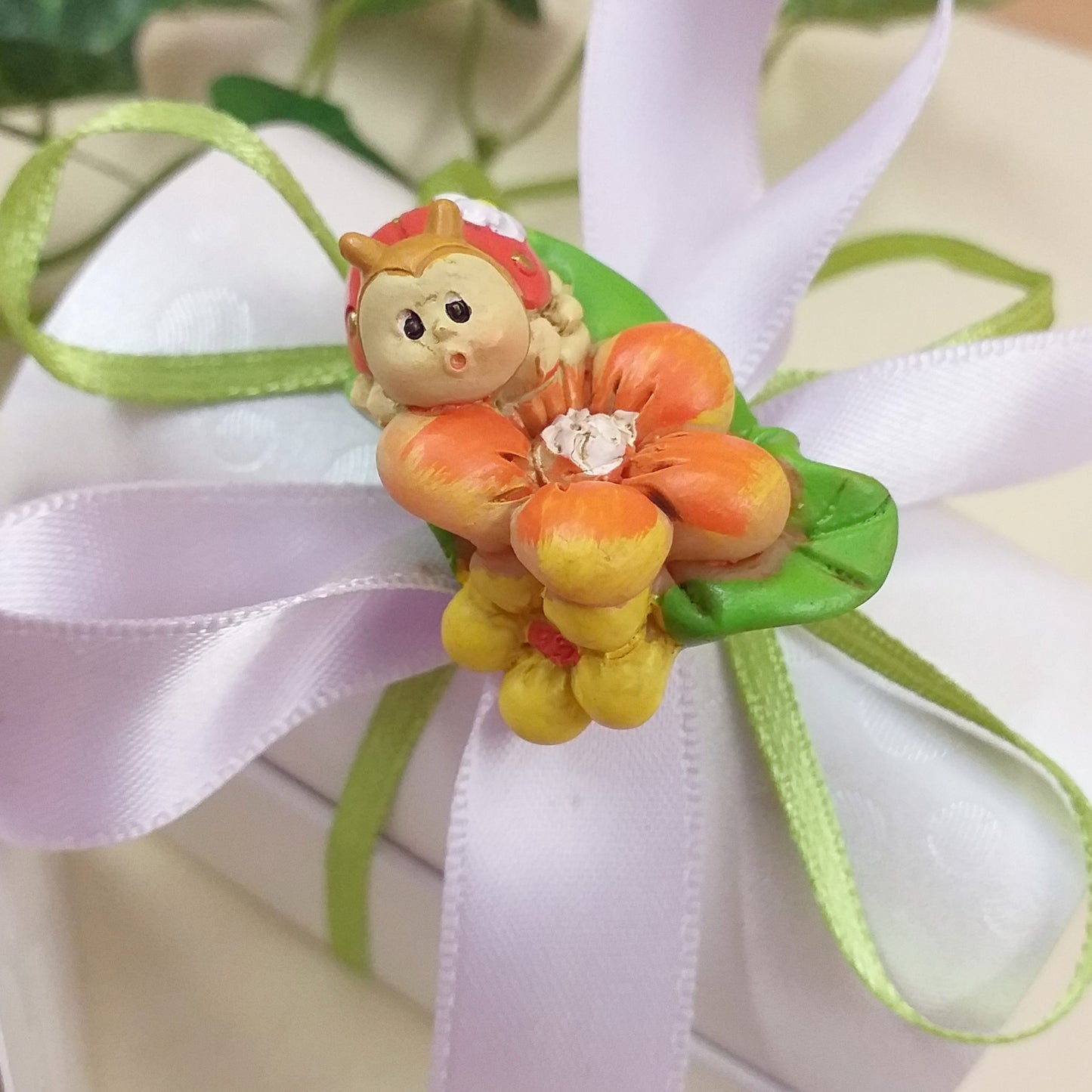 coccinella portafortuna oggettino su fiore effetto-ceramica bomboniere fai da te e confezionate confetti Battesimo matrimonio laurea comunione con scatoline scrigno cofanetto bianco nastrini colorati lilla verde