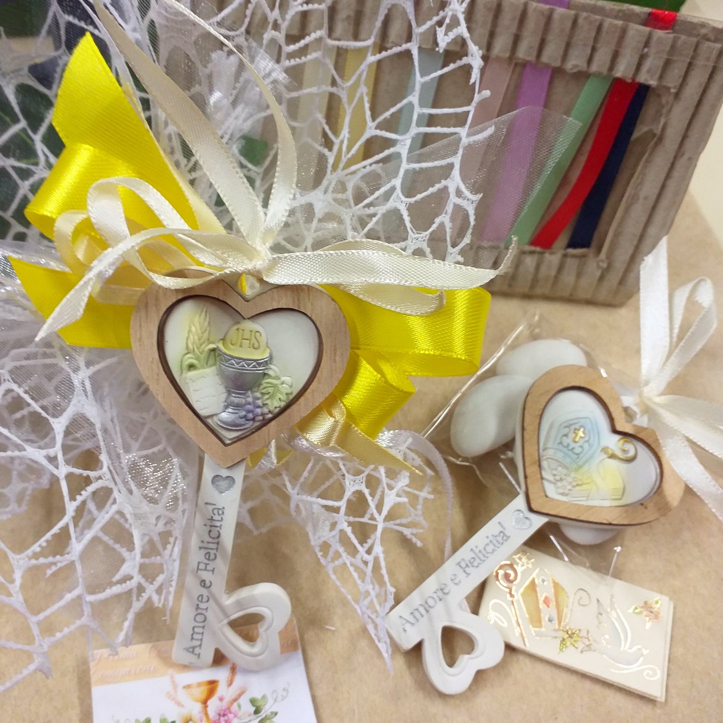 bomboniere forma chiave icona Sacra artistica resina ceramica bordo legno frase scritta Amore e felicità cuore simboli Prima Comunione Santa Cresima bigliettini targhette da stampare nastri colori sacchettino bianco e giallo confezionato confetti