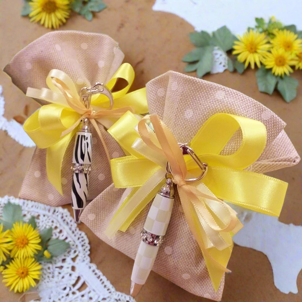 fantasia assortita sacchettino tela rustica beige pois confezionato mini penna biro smaltata zebrata riquadri beige avorio panna portachiavi bomboniera Comunione Cresima con fiocco coccarda nastro giallo