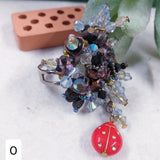 cristalli Swarovski azzurri perle veneziane coccinella rossa shop anelli artigianali bigiotteria di perline perle pietre intreccio schema tecnica fatti a mano con filo e basi su chiodini perni
