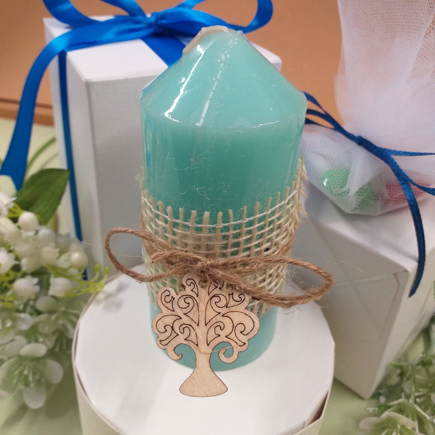 primo piano candela profumata menta colore tiffani-pastello confezionata bomboniera confetti scatola bianca nastro blu packaging green rustico naturale juta corda albero della vita legno