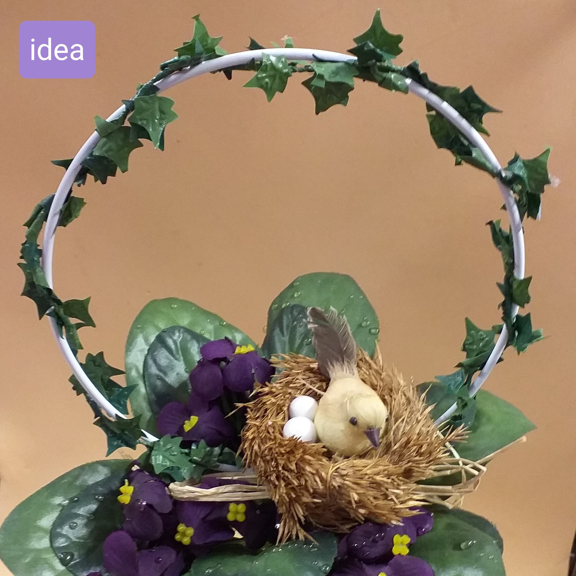 idea fai da te violette composizione floreale con cerchio ferro metallo edera verde nido uccellino ovetti paglia rafia uso coroncine ghirlande pasquali addobbi decorazioni fai da te vetrinistica