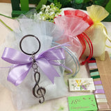 bianco e lilla lavanda sacchetto confezionato confetti per compleanno comunione cresima composizione con portachiavi metallo ciondolo chiave di violino sol bomboniere musica conservatorio