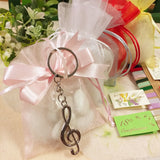 bianco rosa sacchetto confezionato confetti per compleanno comunione cresima composizione con portachiavi metallo ciondolo chiave di violino sol bomboniere musica conservatorio per ragazza