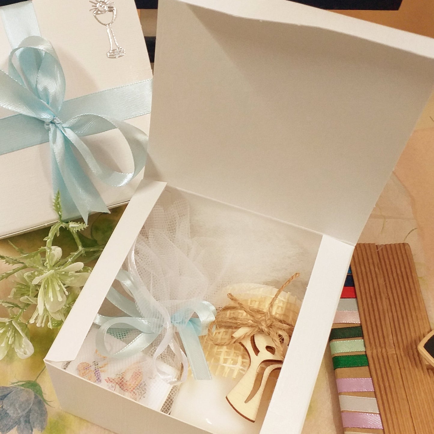 dall'alto scatole bianche basse quadrate coperchio bordo all'interno uso packaging confezionamento oggetti bomboniere fai da te candela croce tau sacchettino confetti