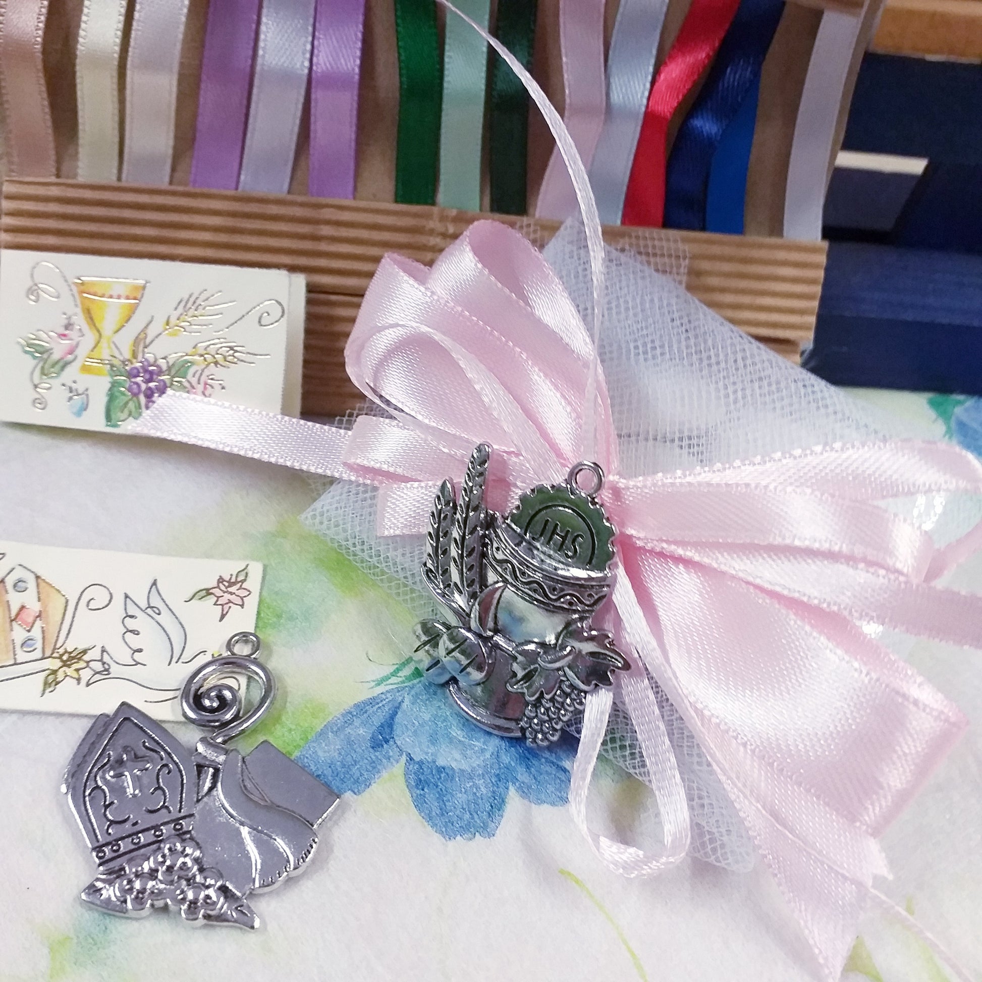 coccarda rosa pastello ciondolo segnaposto Calice Comunione spighe uva pane Mitria Cresima giglio pastorale icona Sacra religiosa applicazione metallo con simboli bigliettino confezione confetti tulle scatolina bomboniera