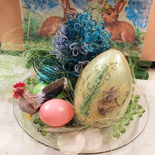 piatto di vetro idea regalo centrotavola pasquale ortensia fiori di perline azzurri blu ovetti di plastica gallo piume decorazioni addobbi petali sassolini vetro uovo grande mughetti violette sfondo vetrina runner coniglietti