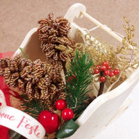 dettaglio slitta legno pick bacche rosse candela nastro buone feste pigne natalizie composizione floreale fioristi perline veneziane idee regalo centrotavola Natale