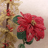 primo piano stella di natale composizione floreale fioristi perline veneziane idee regalo centrotavola rametti dorati bacche rosse artigianali