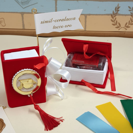 modello simil ceralacca tocco oro scatolina originale portaconfetti bomboniera laurea segnaposto festa confezionata confetti bigliettino personalizzabile con colore nastrino raso, allestimento con tocco cappello e nappina muro con simboli grafici  corona alloro 
