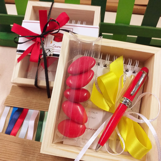 set di scrittura astuccio legno e plastica scritta laurea penna rossa biro mini block notes ciondolo cappello tocco tubo portaconfetti confetti rossi coccarda nastro confezionata artigianale