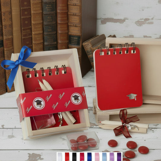 set di scrittura astuccio legno plastica scritta laurea matite mini block notes ciondolo cappello tocco scatolina trasparente portaconfetti confetti rossi coccarda nastro confezionata artigianale fiocchetto blu