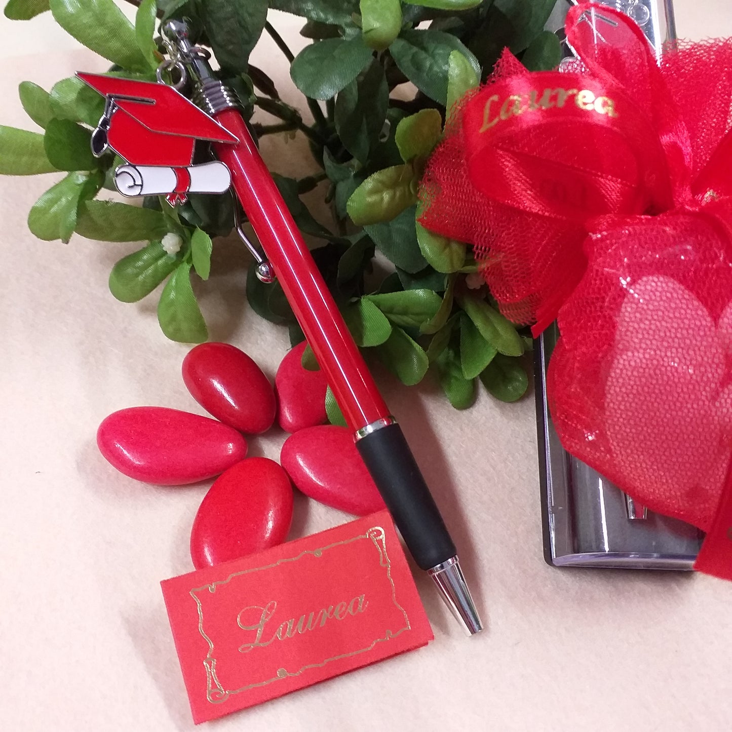 dettagli penna bomboniera laurea biro rossa nera ciondolo charms tocco cappello pergamena confetti rossi bigliettino sacchettino pompon tulle nastro stampato scritta scatolina astuccio confezionato packaging artigianale