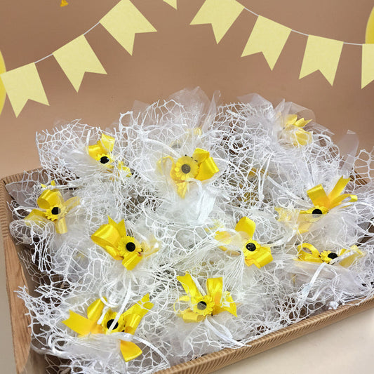 allestimento prima comunione santa cresima sacchettini a retina bianca confezionati come bomboniere con girasoli nastro confetti vassoio cesto di cartoncino