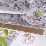 idee creare biglietto auguri con cupido tag tondo arco freccia cuoricino san valentino etichetta adesiva sticker packaging confezione regalo fioristi enogastronomia