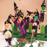 dall'alto decorazioni e addobbi feste nero-verde e viola streghetta befanella Halloween stecco legno fioristi con ramazza scopina portafortuna rafia bambola di pezza pannolenci feltro per decorazioni casa negozio Befana Epifania