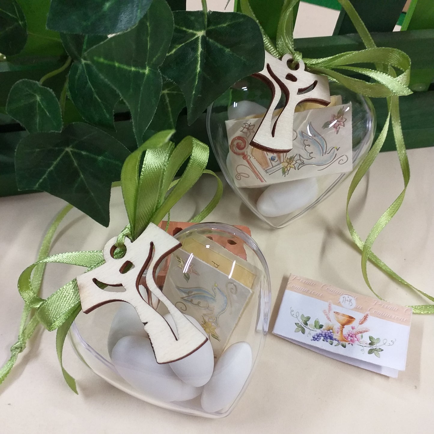 cuori plastica portaconfetti plexiglass bomboniera comunione confetti bianchi confezionati con Croce Tau Francescana legno ciondolo sacro religioso bigliettino nastrino verde