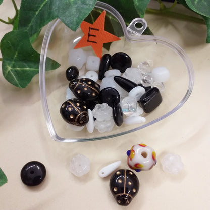 E lotto misto palline sferette coccinelle dado fiorellini perle scatola cuore 25 grammi perline di vetro nero trasparente colore cristallo sfuse stile murano veneziane uso fai da te bigiotteria gioielli bijoux collane orecchini